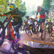 Riders Republic cyclists bike down a wooden bridge on a mountain hill.